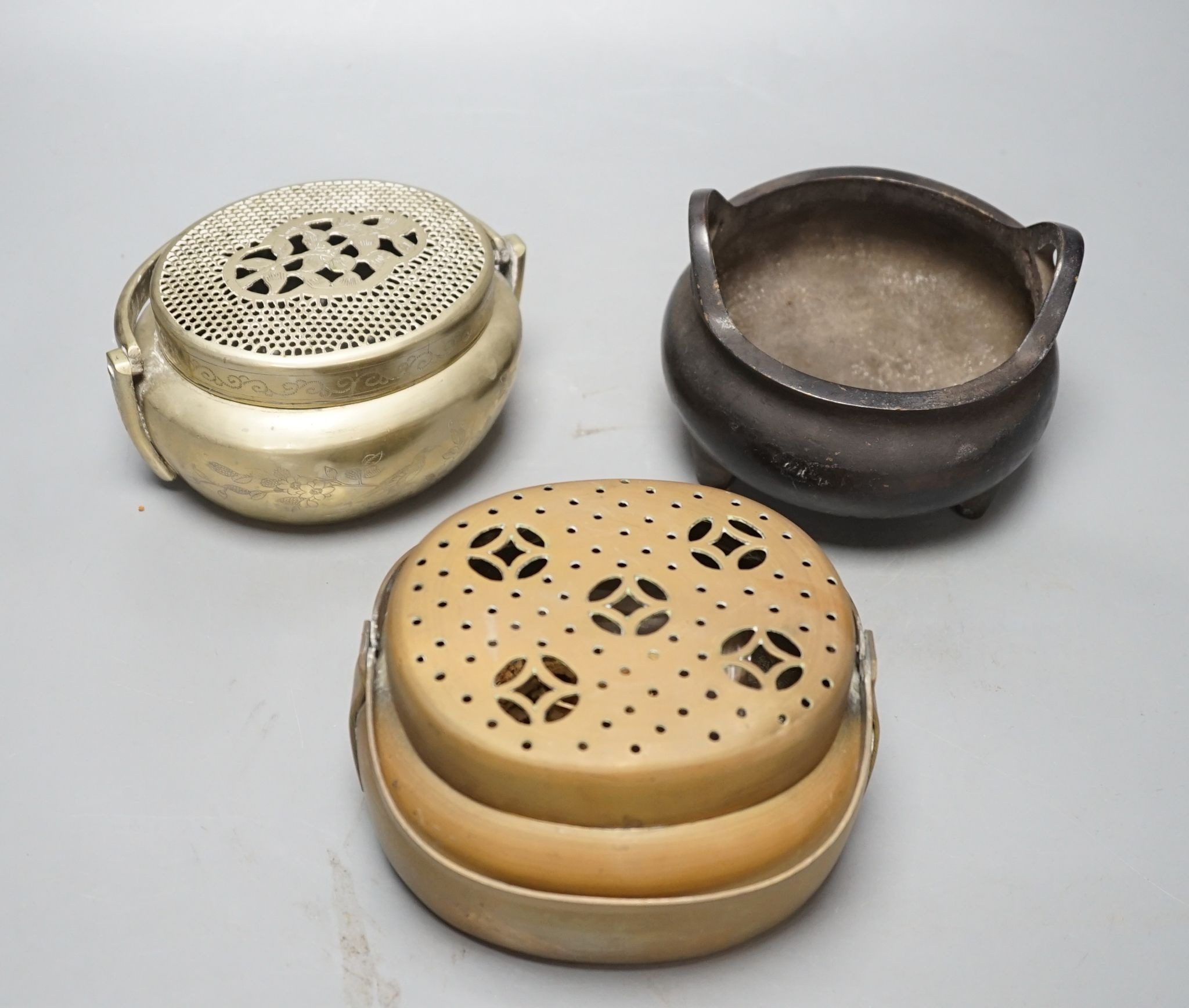A Chinese bronze tripod censer, 13.5cm and two brass or bronze hand warmers